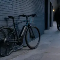 Vélo à assistance électrique garé devant un immeuble urbain en fin de journée