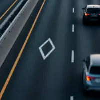 Route à plusieurs voies avec un losange blanc au sol sur la voie de gauche