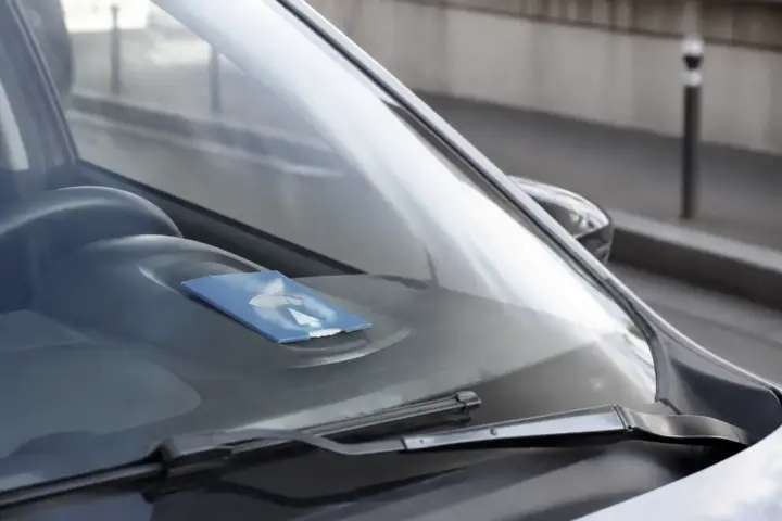 Disque de stationnement bleu posé sur le tableau de bord d’une voiture garée en zone bleue